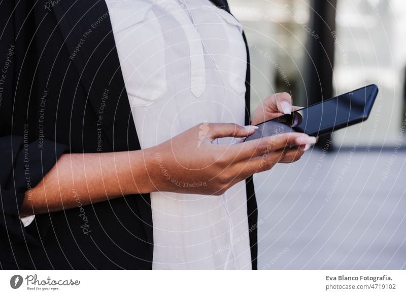 Unbekannte Geschäftsfrau in der Stadt, die ein Mobiltelefon benutzt - Wirtschaft und Technik im Freien unkenntlich Laptop Computer Afro-Look Frau Business Café