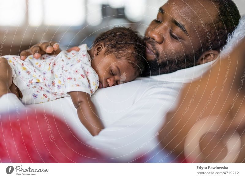 Vater hält sein Baby zu Hause in den Armen Papa Kinder neugeboren Familie Vaterschaft echte Menschen im Innenbereich heimwärts flach Appartement genießen