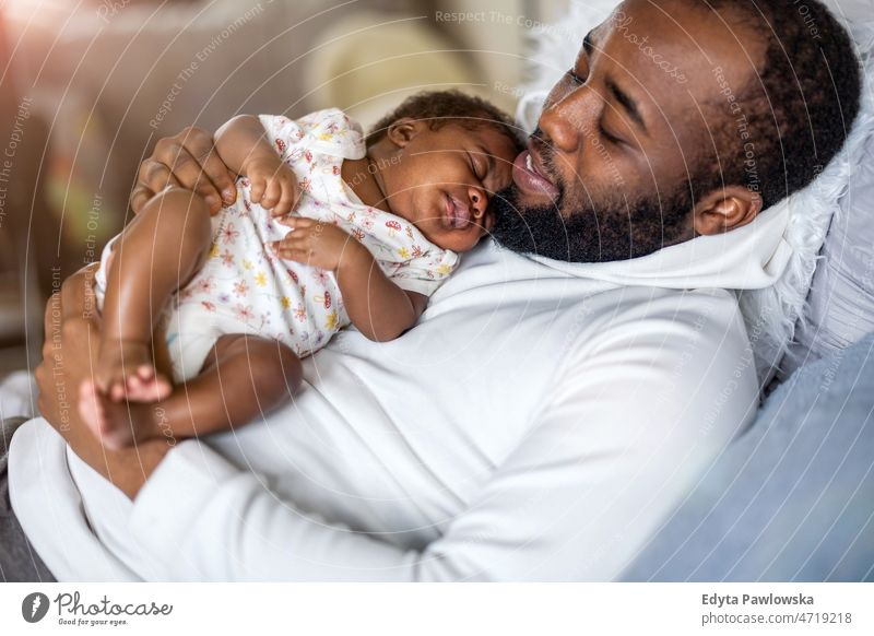 Vater hält sein Baby zu Hause in den Armen Papa Kinder neugeboren Familie Vaterschaft echte Menschen im Innenbereich heimwärts flach Appartement genießen