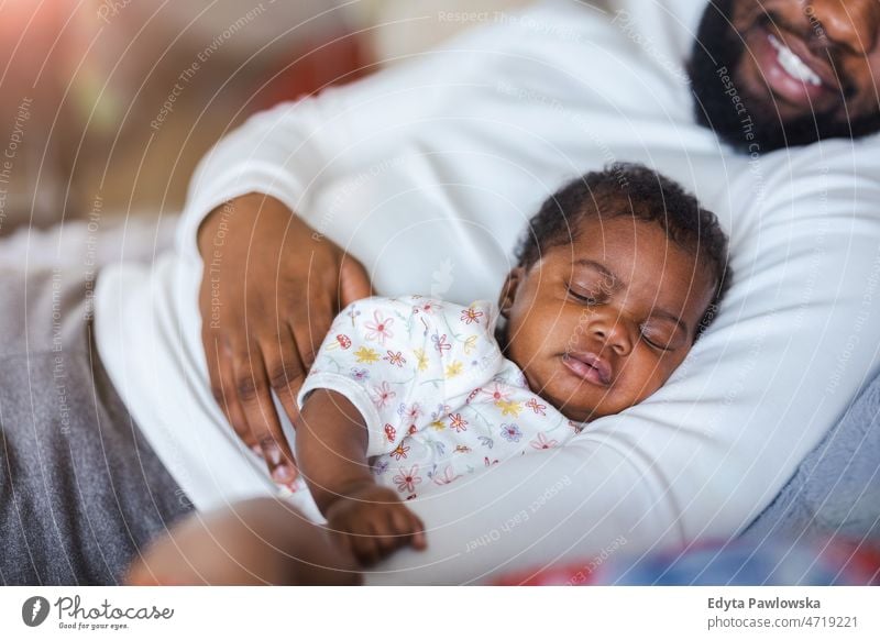 Vater hält sein Baby zu Hause in den Armen Papa Kinder neugeboren Familie Vaterschaft echte Menschen im Innenbereich heimwärts flach Appartement genießen