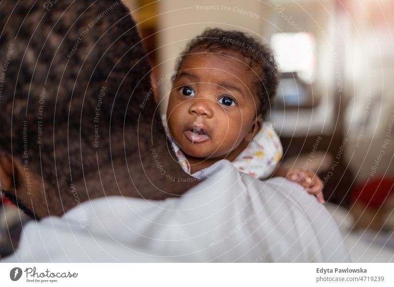 Vater hält sein Baby zu Hause in den Armen Papa Kinder neugeboren Familie Vaterschaft echte Menschen im Innenbereich heimwärts flach Appartement genießen