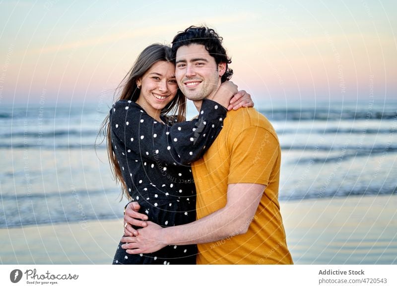 Fröhliches Paar, das sich am Strand umarmt kuscheln Streicheln Partnerschaft Liebe romantisch Zuneigung Umarmung Ufer Bonden Termin & Datum Küste Zusammensein