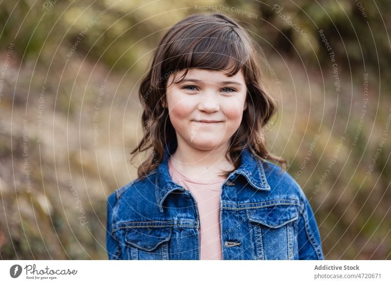 Charmantes Mädchen in Jeansjacke in der Natur Vorschein Kind sorgenfrei Individualität positiv Porträt Landschaft Kindheit charmant niedlich angenehm neugierig