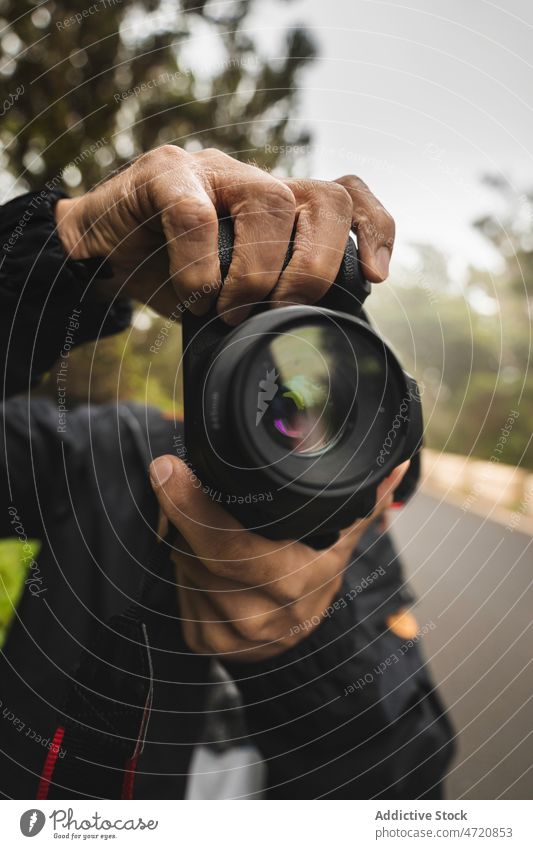 Unbekannter Mann mit Fotokamera auf der Straße Fotograf Fotoapparat Fotografie fotografieren Linse professionell schießen einfangen Baum Hobby Moment Gedächtnis