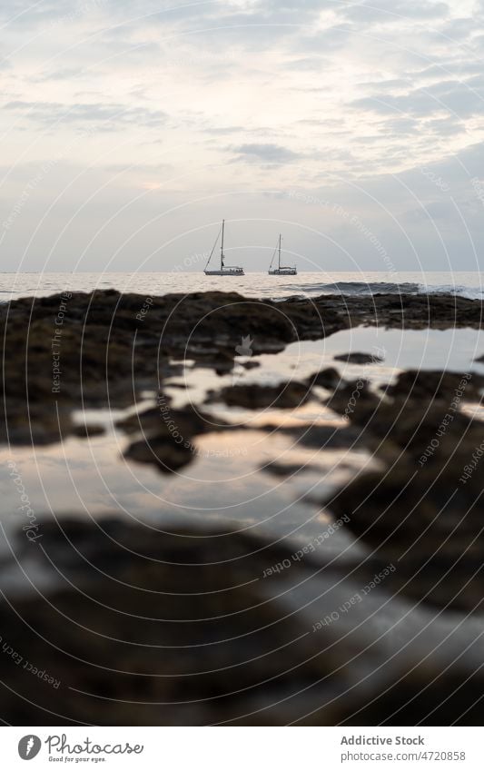 Segelboote schwimmen bei Sonnenuntergang auf kräuselndem Meer MEER Meereslandschaft felsig Natur Küste Insel wild Umwelt Wasser marin Landschaft Rippeln Ufer