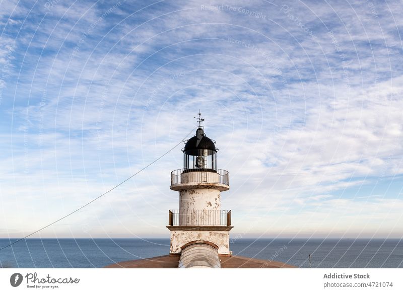 Leuchtturm unter bewölktem Himmel gegen das Meer Leuchtfeuer Örtlichkeit Top navigieren wolkig MEER Blauer Himmel Himmel (Jenseits) Seeküste malerisch Szene