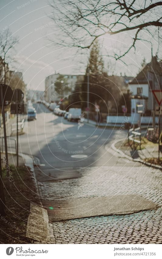 autofreie Straßenkreuzung in der Wintersonne Autofrei Sonntag Kreuzung Fußweg Herbst vintage film retro analog Straßenrand Asphalt grau leer urban Straßenbelag