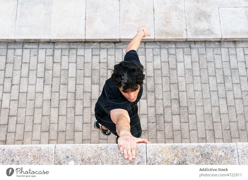 Mann hält Hand an Wand und hängt Training Straße passen Halt hängen Athlet Händchen haltend Großstadt männlich Typ Le Parkour Übung Fitness Borte Sportler urban