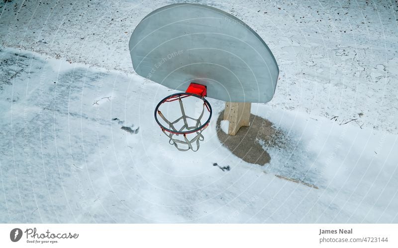 Ein hoher und langhalsiger Basketballplatz im Winter punkten Freizeitspiele Straße Frost Tor Rückwand Hintergrund orange Schnee Stadtleben Sportstätte Netz Korb