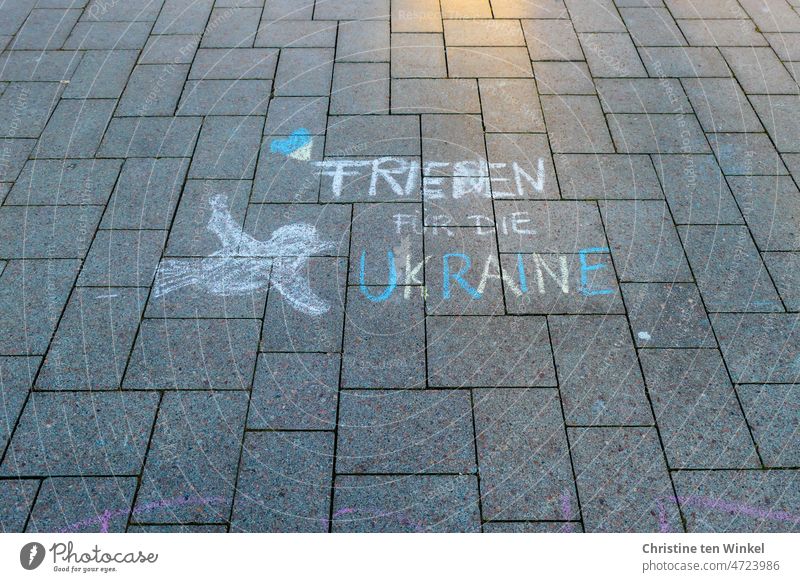 "Frieden für die Ukraine" , ein Herz und eine Friedenstaube. Mit Strassenmalkreide auf den Marktplatz gemalt. Friedenserklärung Friedensangebot Peace