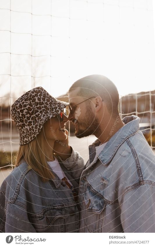 Freundin und Freund in den Zaun schauen sich gegenseitig und berühren Nasen. Glückliches Paar. berührend Hände Frau Mann Liebe Zusammensein jung Partnerschaft