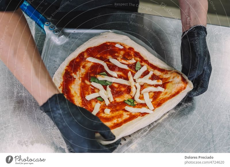 Zubereitung einer hausgemachten Pizza nach italienischer Art durch einen Fachmann backen Bäcker Bäckerei Käse Küchenchef Koch Kochen Essen zubereiten