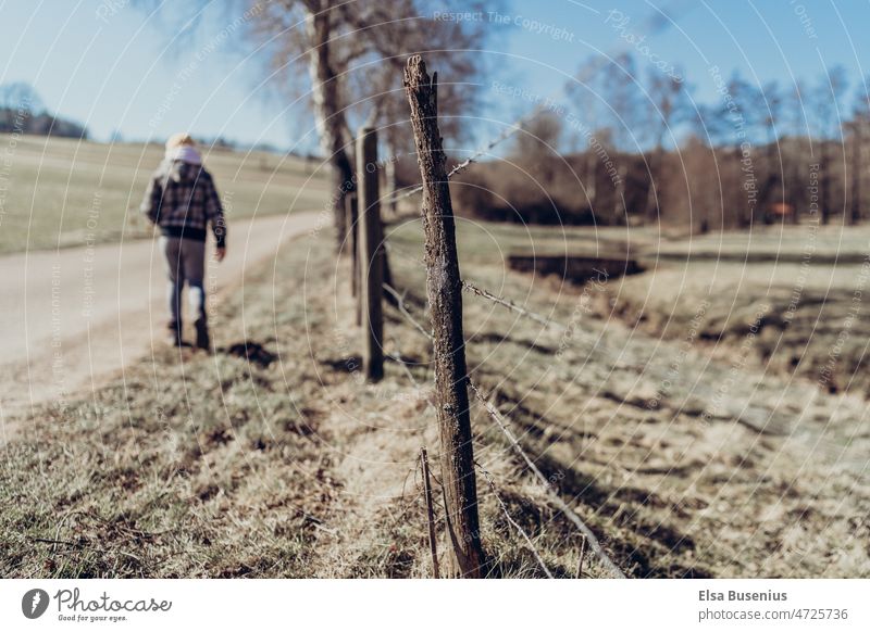 Spazieren bei Sonnenschein Kind spazieren sonne sonnenschein licht draußen weg natur klima winter frühling herbst zaun Weidezaun Außenaufnahme Landschaft Wiese