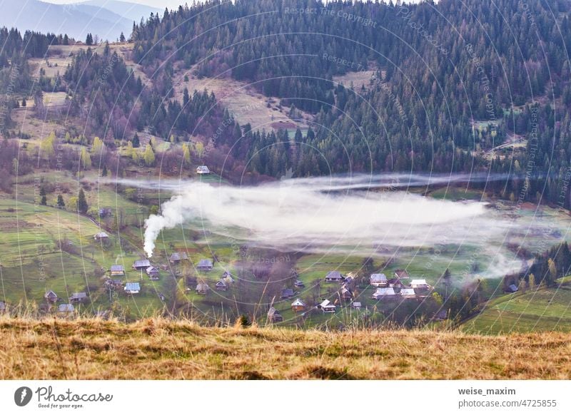 Schöne Frühlingslandschaft. Traditionelle Bergdorf auf den Hügeln. Ländliche Ukraine Karpaten Sonnenaufgang. Rauch aus dem Haus Berge u. Gebirge Natur