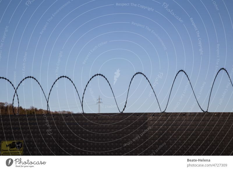 Frühling hinterm Stacheldraht blauer Himmel Bedrohung gesperrt Elektrizitätsversorgung kein Zugang Krieg Zaun Barriere Stacheldrahtzaun Grenze gefährlich