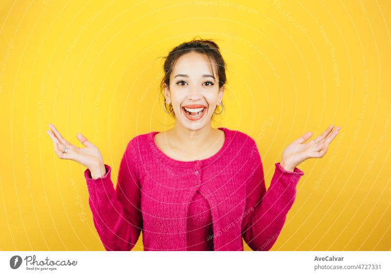 Junge Frau mit rosa Hemd, die nicht weiß, was sie tun soll, hebt die Hände. Junge Frau Haltung. Gelber Ton Farbe Hintergrund, Ausdruck der normalen Menschen. Mockup-Konzept mit Menschen