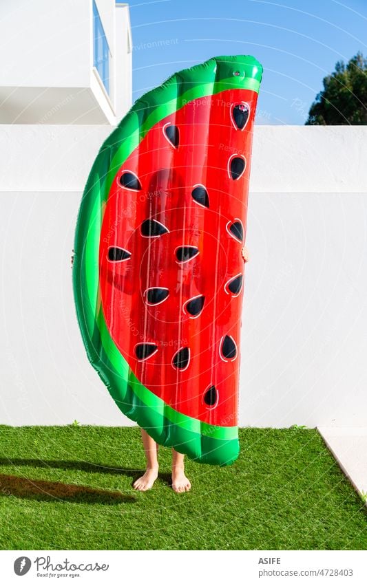 Teenager-Mädchen hält eine aufblasbare Matratze in Form einer Wassermelone in der Nähe des Schwimmbads Schlafmatratze Pool Sommer Schwimmer Kind Urlaub Spaß