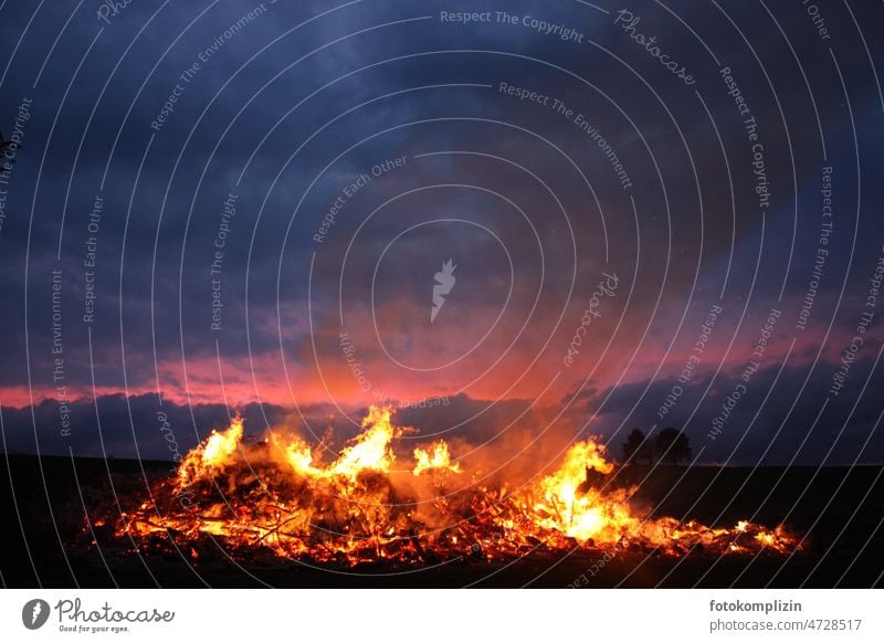 Osterfeuer oder Maifeuer Feuer Brand heiß brennen Feuerstelle Wärme Glut Nacht glühen glühend Flamme Flammen groß Dämmerung Himmel Hitze Außenaufnahme orange