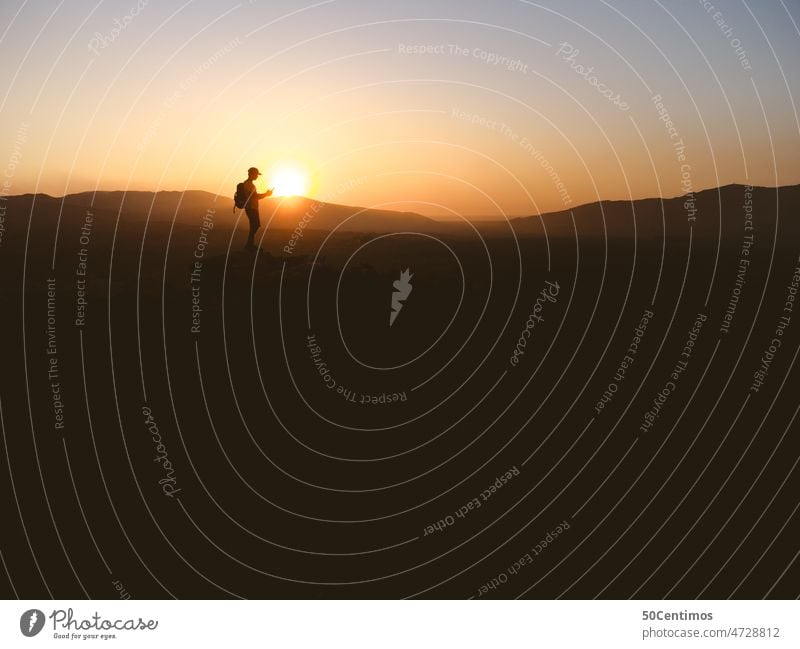 Silhouetten von Drohnenpilot Spaziergang Ausflug Außenaufnahme Landschaft Himmel Gegenlicht Schönes Wetter Sonne Wüste Berge Farbfoto von hinten Natur