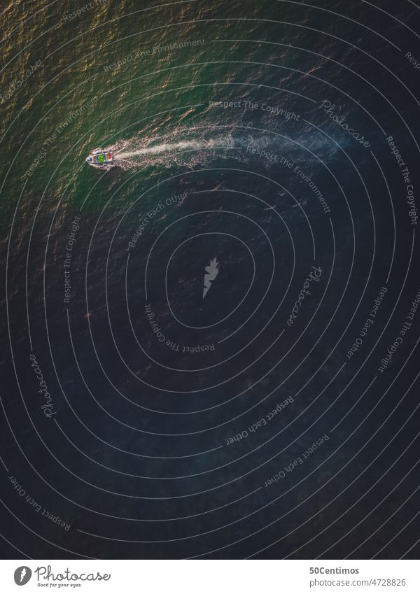 Boot im Meer von hoch oben Meerwasser grün Wasserfahrzeug Schifffahrt Küste Bootsfahrt Ruderboot Sonnenlicht Drohnenansicht Luftaufnahme Fischerboot