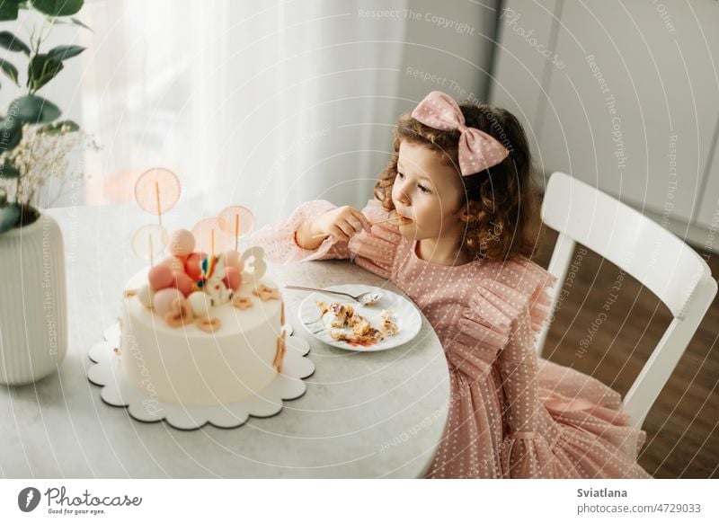 Niedliches kleines Mädchen isst an ihrem Geburtstag einen Geburtstagskuchen mit einem Löffel Kuchen Kind wenig hübsch essen heimwärts Glück Spaß süß