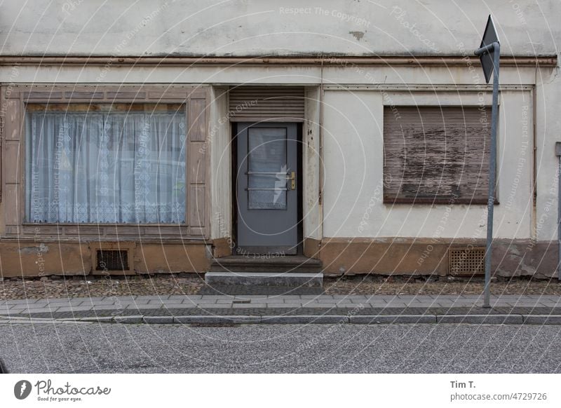 eine Ladenwohnung ? Lausitz Dorf Fenster Ladengeschäft Gardine Straße Bürgersteig Haus Fassade Menschenleer Außenaufnahme Farbfoto Tag Wand Gebäude Stadt