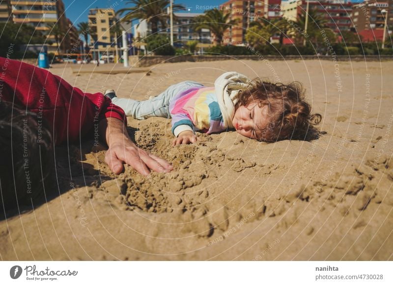 Kleines Mädchen spielt mit ihrem Vater im Sand Strand Familie Freude spielen spielerisch Glück Fröhlichkeit Kleinkind Papa Single Übung teilen Pflege