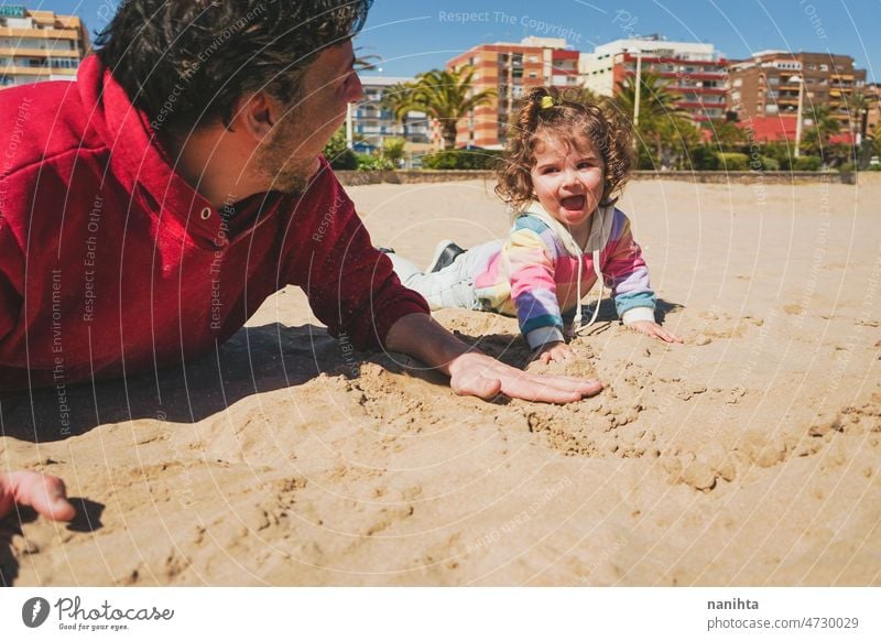 Kleines Mädchen spielt mit ihrem Vater im Sand Strand Familie Freude spielen spielerisch Glück Fröhlichkeit Kleinkind Papa Single Übung teilen Pflege