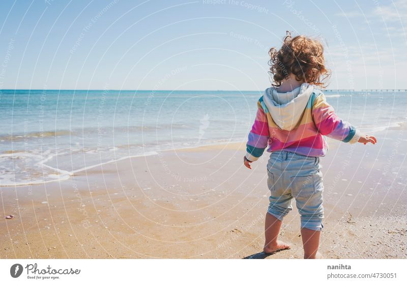 Großansicht eines kleinen Mädchens mit Regenbogen-Kapuzenpulli beim Spielen am Strand Freiheit Fröhlichkeit Feiertage Baby Kleinkind Familie frei MEER Ufer