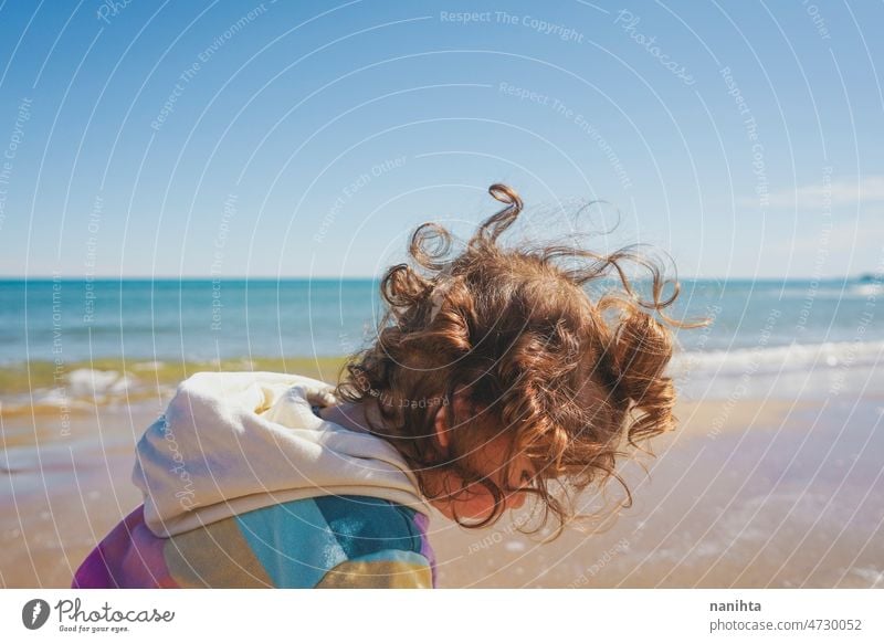 Mittelteil eines kleinen Mädchens beim Spielen am Meer Porträt Baby bezaubernd Strand Sommer lockig Behaarung Freude genießen Kleinkind Regenbogen Süßer