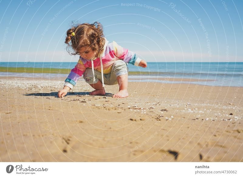 Großansicht eines kleinen Mädchens mit Regenbogen-Kapuzenpulli beim Spielen am Strand Freiheit Fröhlichkeit Feiertage Baby Kleinkind Familie frei MEER Ufer