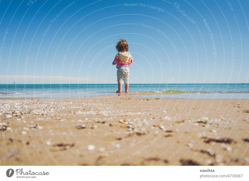 Großansicht eines kleinen Mädchens mit Regenbogen-Kapuzenpulli beim Spielen am Strand Freiheit Fröhlichkeit Feiertage Baby Kleinkind Familie frei MEER Ufer