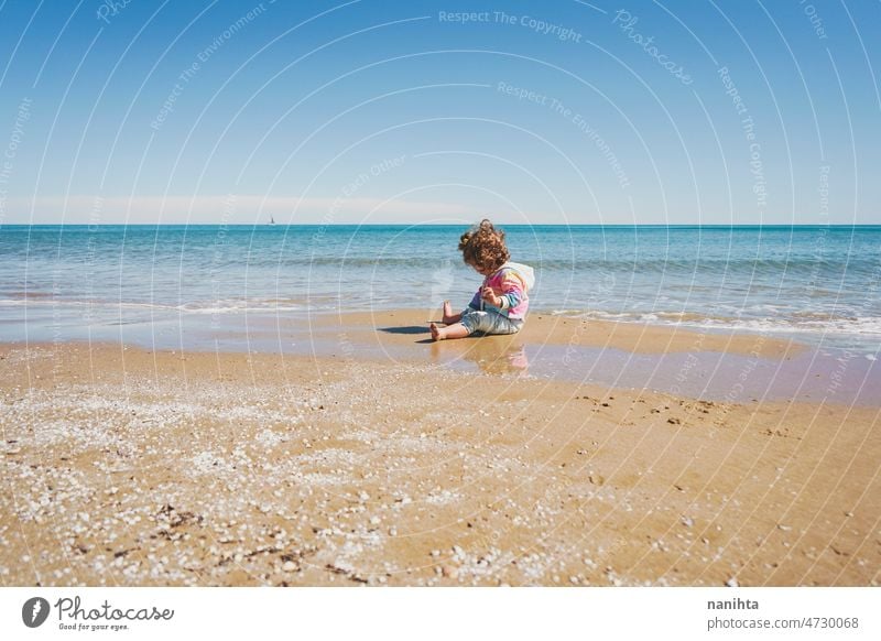 Großansicht eines kleinen Mädchens mit Regenbogen-Kapuzenpulli beim Spielen am Strand Freiheit Fröhlichkeit Feiertage Baby Kleinkind Familie frei MEER Ufer