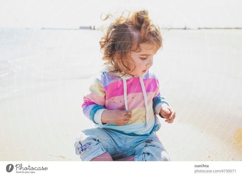 Mittelteil eines kleinen Mädchens beim Spielen am Meer Porträt Baby bezaubernd Strand Sommer lockig Behaarung Freude genießen Kleinkind Regenbogen Süßer