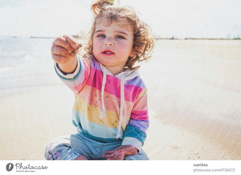 Mittelteil eines kleinen Mädchens beim Spielen am Meer Porträt Baby bezaubernd Strand Sommer lockig Behaarung Freude genießen Kleinkind Regenbogen Süßer