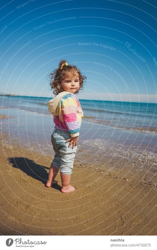 Großansicht eines kleinen Mädchens mit Regenbogen-Kapuzenpulli beim Spielen am Strand Freiheit Fröhlichkeit Feiertage Baby Kleinkind Familie frei MEER Ufer