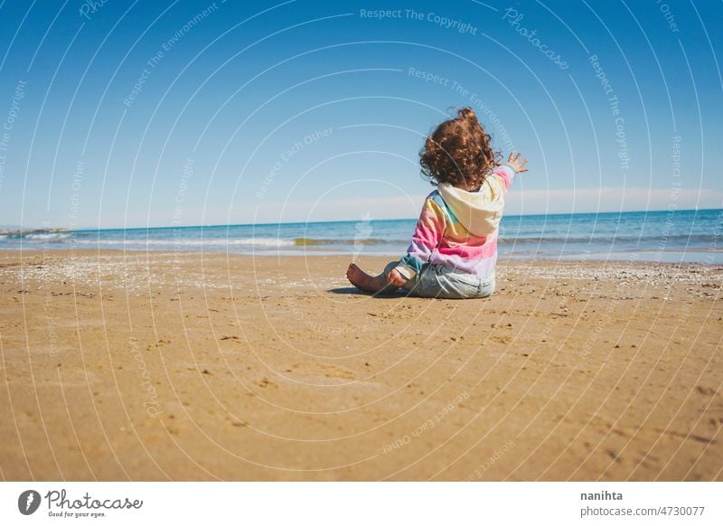 Großansicht eines kleinen Mädchens mit Regenbogen-Kapuzenpulli beim Spielen am Strand Freiheit Fröhlichkeit Feiertage Baby Kleinkind Familie frei MEER Ufer