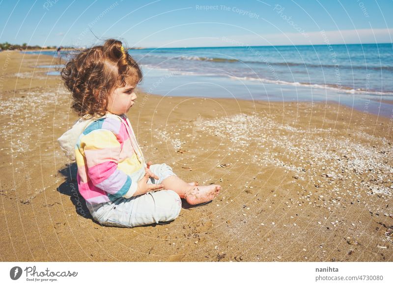 Mittelteil eines kleinen Mädchens beim Spielen am Meer Porträt Baby bezaubernd Strand Sommer lockig Behaarung Freude genießen Kleinkind Regenbogen Süßer