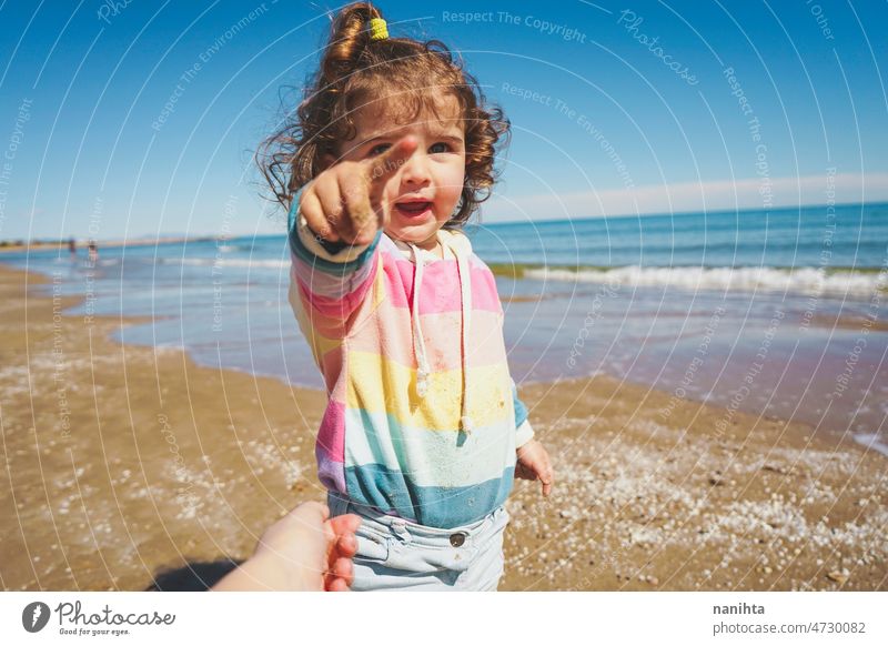 Mittelteil eines kleinen Mädchens beim Spielen am Meer Porträt Baby bezaubernd Strand Sommer lockig Behaarung Freude genießen Kleinkind Regenbogen Süßer