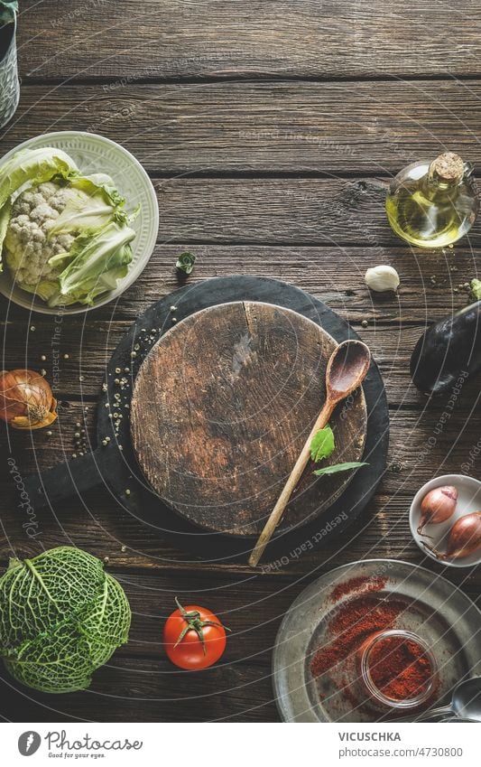 Lebensmittel Hintergrund mit hölzernen Schneidebrett, Kochlöffel und gesunde Zutaten Lebensmittelhintergrund Gesundheit Wirsing Blumenkohl Tomaten Gewürze