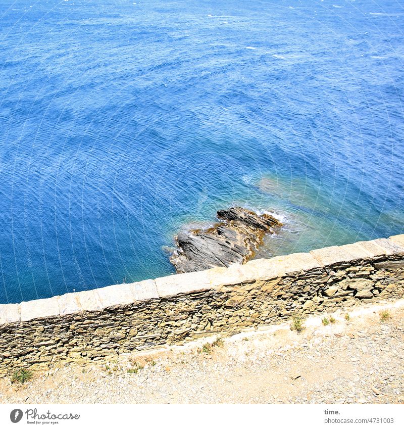 Blick über den Tellerrand mauer wasser felsen weg sonnig warm blau mittelmeer wellen umspülen reisen tief küste bucht brandung trockenmauer