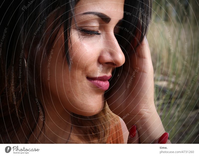 Frau, die Sonne genießend frau portrait feminin langhaarig dunkelhaarig sonnig geschlossene augen hand halten träumen ruhe meditation natur wiese