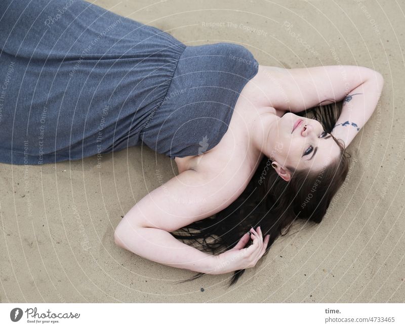 liegende Frau mit Blick zum Himmel frau kleid feminin langhaarig dunkelhaarig tattoo sand glücklich schauen blick nach oben