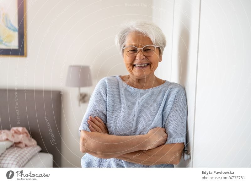 Porträt einer lächelnden älteren Frau zu Hause Brille allein häusliches Leben Oma Großmutter graue Haare heimwärts im Innenbereich Lifestyle reif alt