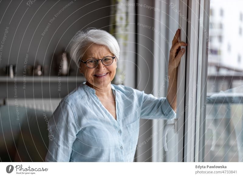 Porträt einer lächelnden älteren Frau zu Hause Brille allein häusliches Leben Oma Großmutter graue Haare heimwärts im Innenbereich Lifestyle reif alt