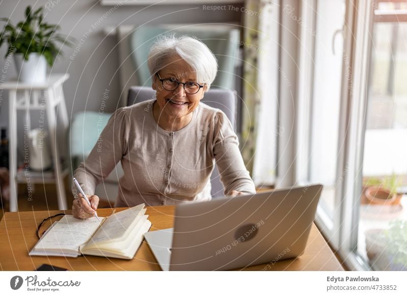 Ältere Frau benutzt Laptop zu Hause Brille allein häusliches Leben älter Oma Großmutter graue Haare heimwärts im Innenbereich Lifestyle reif alt eine Person