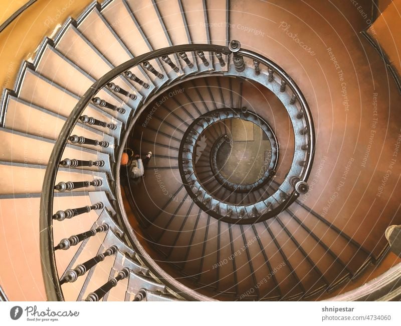 Draufsicht auf eine Wendeltreppe in einem Altbau vogelperspektive Frau Schnecke Treppenhaus Haus Stufen Geländer braun alt Berlin Kreuzberg drehen