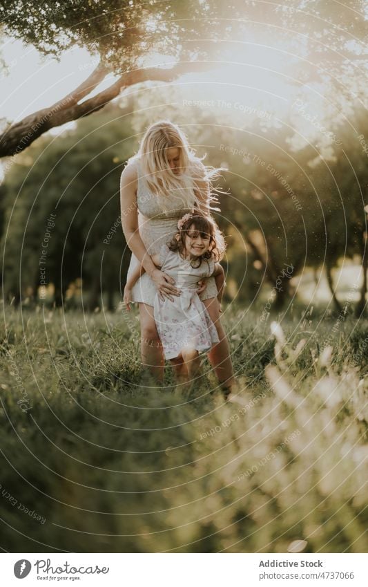 Fröhliches Mädchen und schwangere Mutter genießen den Sommer auf einer Wiese Frau Tochter Zusammensein Park Wald Kind Glück warten Schwangerschaft mütterlich