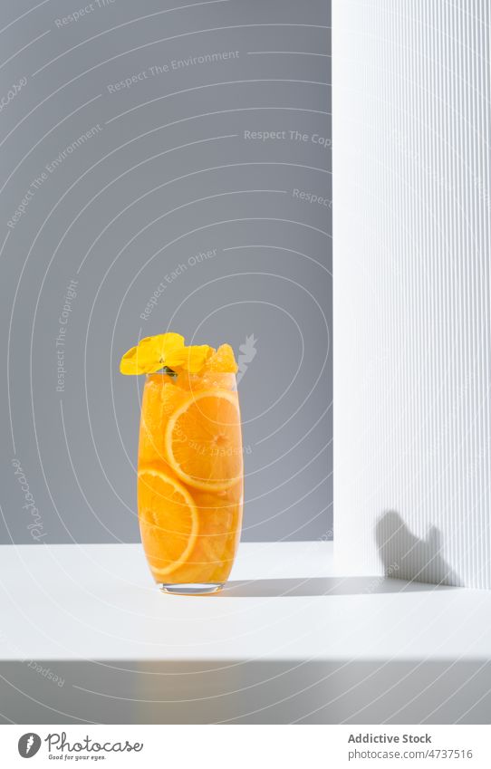 Glas mit erfrischendem Orangengetränk auf weißem Tisch orange Saft Getränk dienen Sonnenlicht Erfrischung Blume trinken lecker geschmackvoll hell Zitrusfrüchte