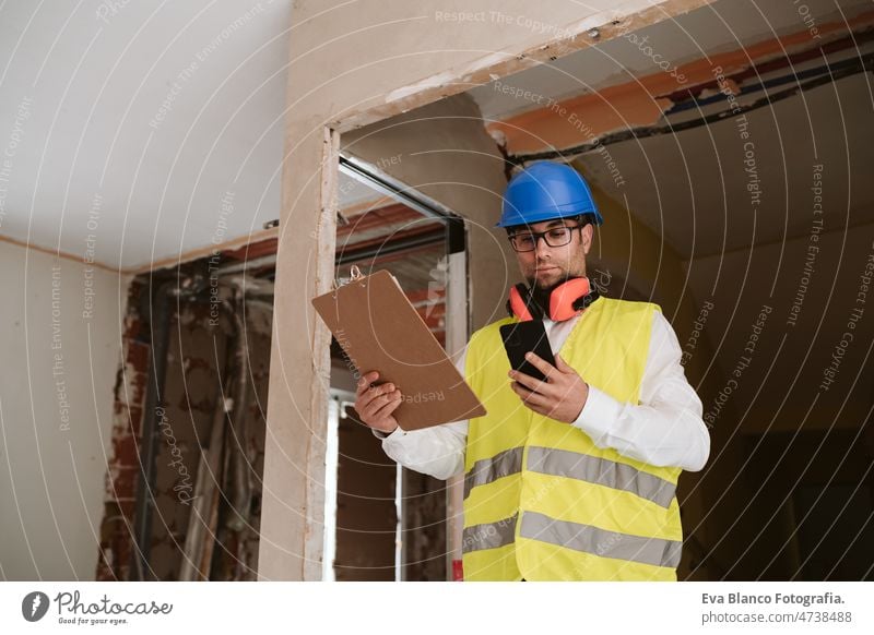 Vorarbeiter oder Architekt bei der Arbeit an Handy-Bauplänen .Baustelle. Heimwerken Polier Blaupausen Technik & Technologie Internet Haus professionell